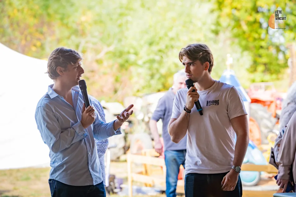 Louis Pauget interviewe un intervenant, chacun avec un micro, à la Fête du Vincuit